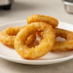 Croccanti anelli di cipolla preparati nella friggitrice ad aria con un sapore irresistibile.